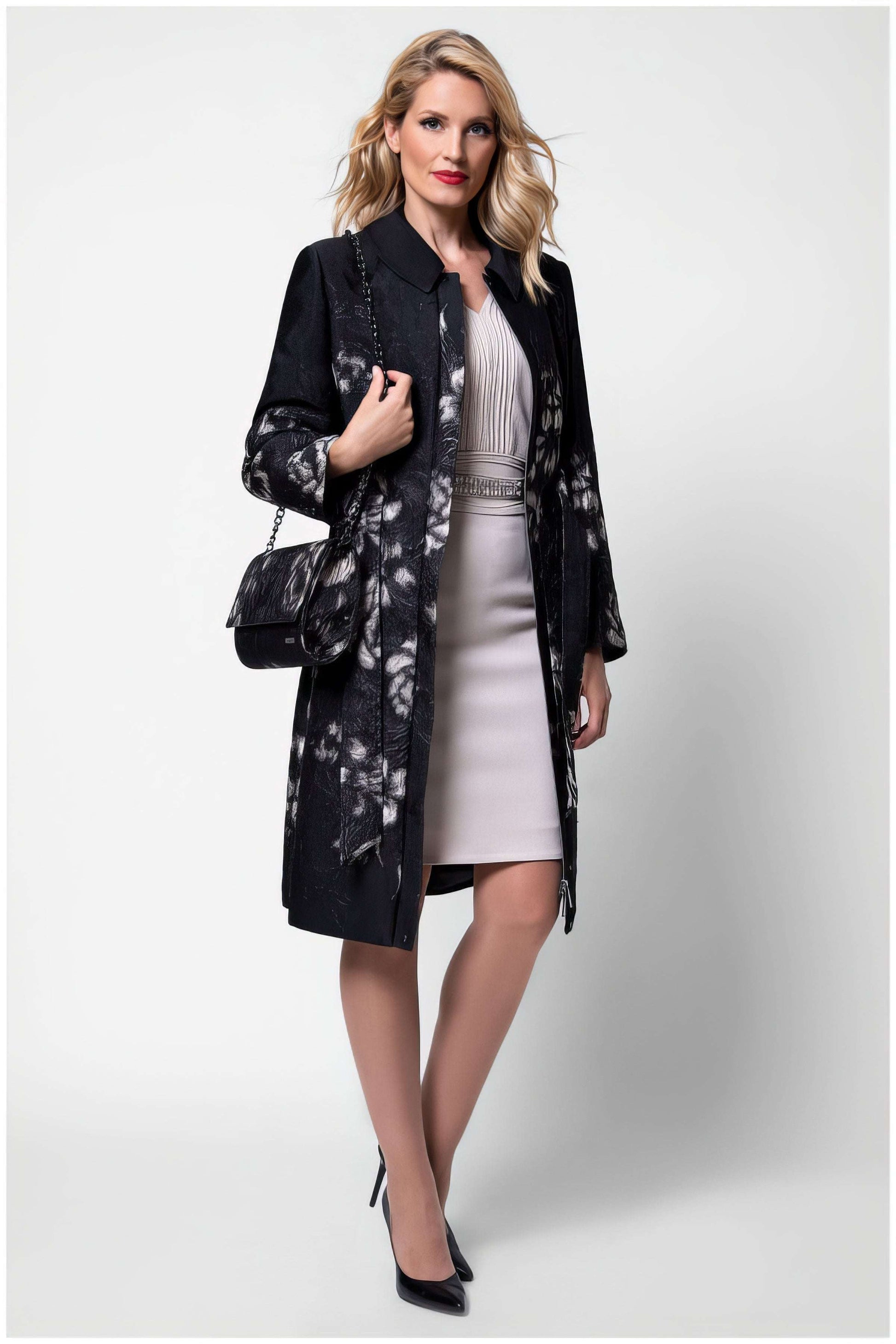Woman wearing Emma Light Coat with Silver Floral Jacquard over elegant dress posing with black handbag and heels
