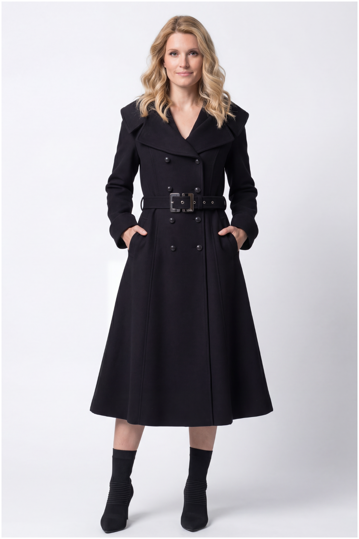 Woman wearing a black coat with a belt on a white background