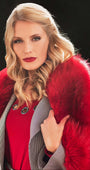 Woman wearing a red Luna Fashion House coat with a fur collar outdoors