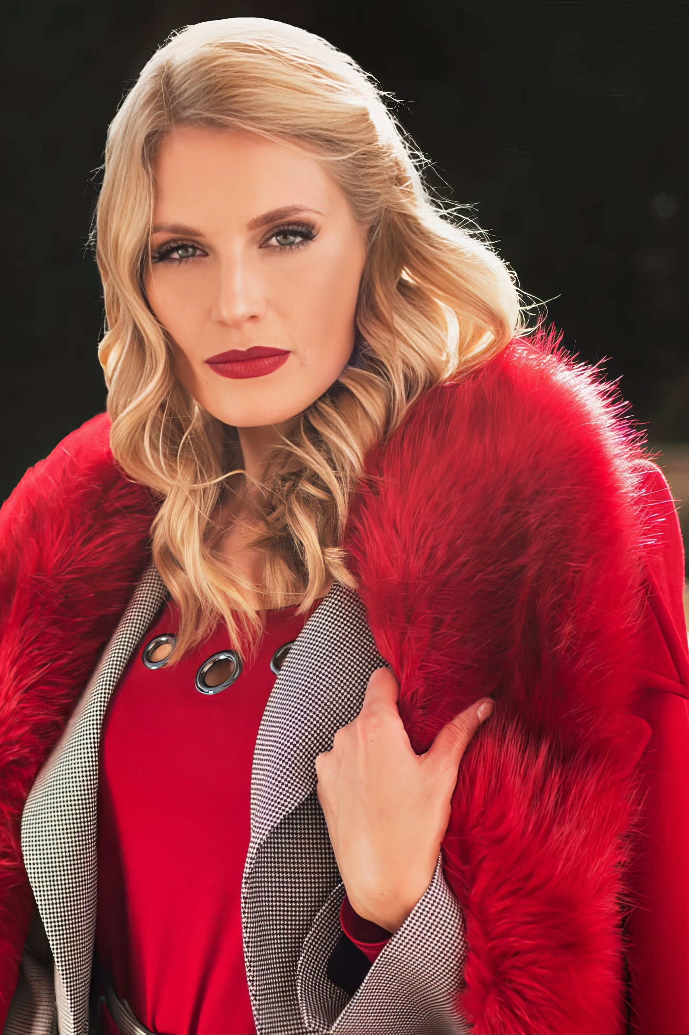 Woman wearing a red Luna Fashion House coat with a fur collar outdoors