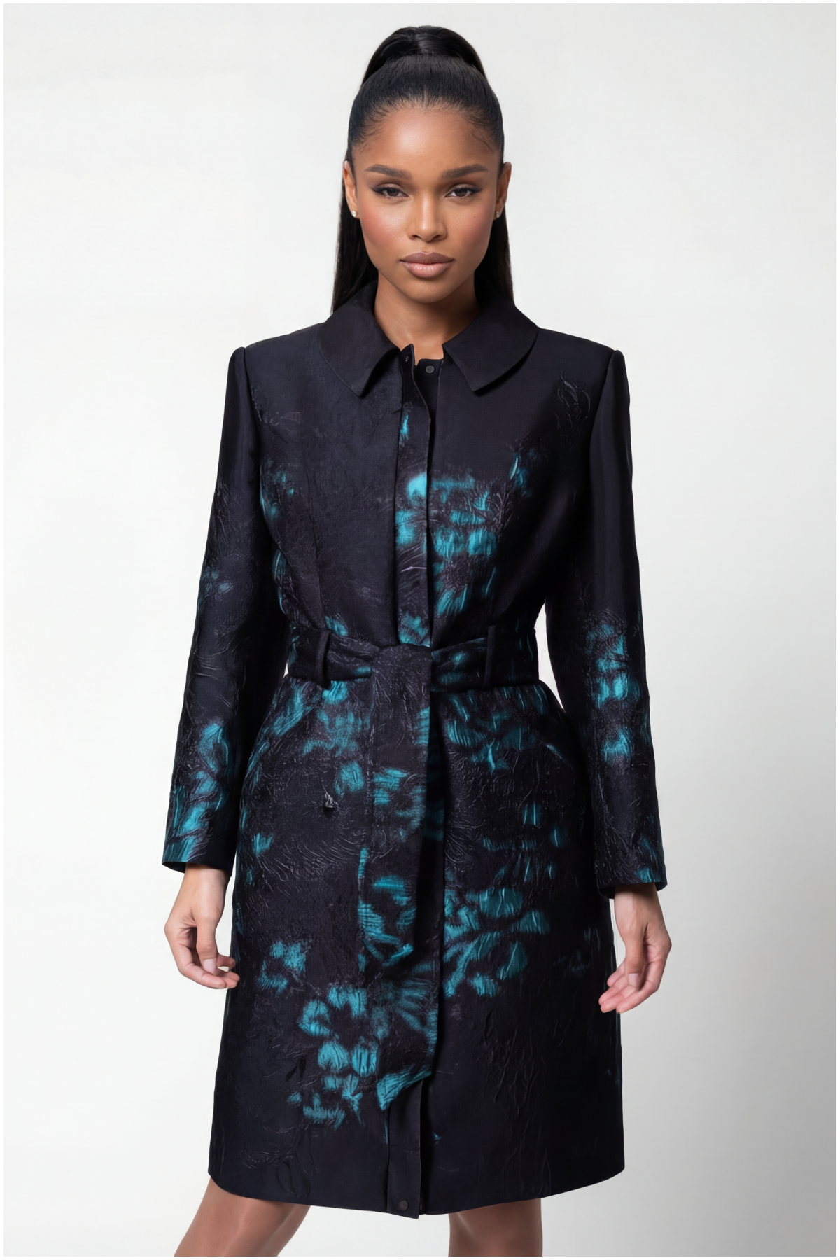 Woman wearing a black coat with blue floral patterns on a white background