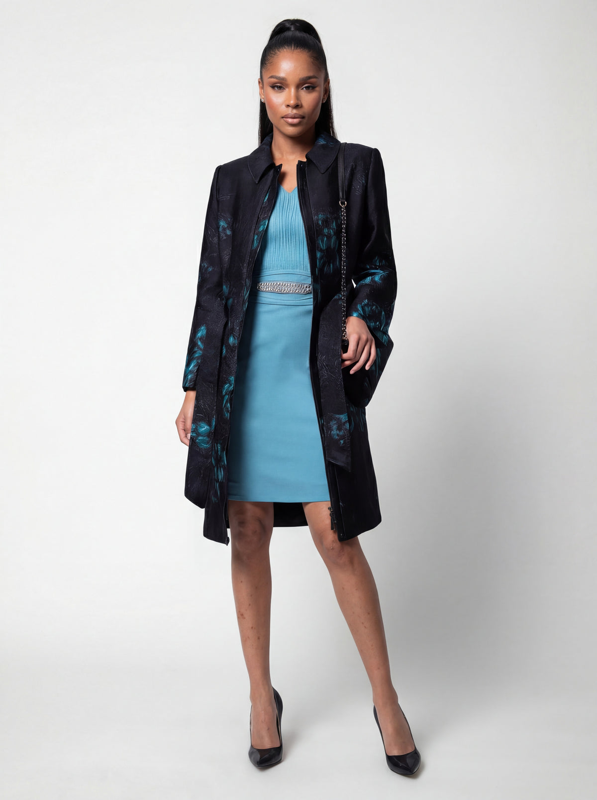 Teal Floral Jacquard Light Coat, Emma. Full length on the model over a light blue dress.